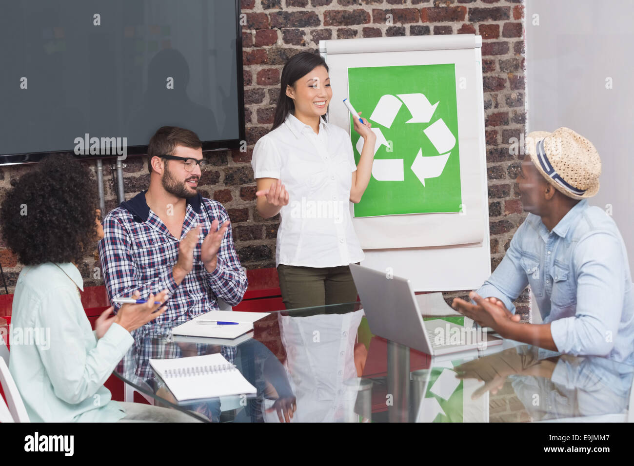 Team in meeting with recycling symbol on whiteboard Stock Photo