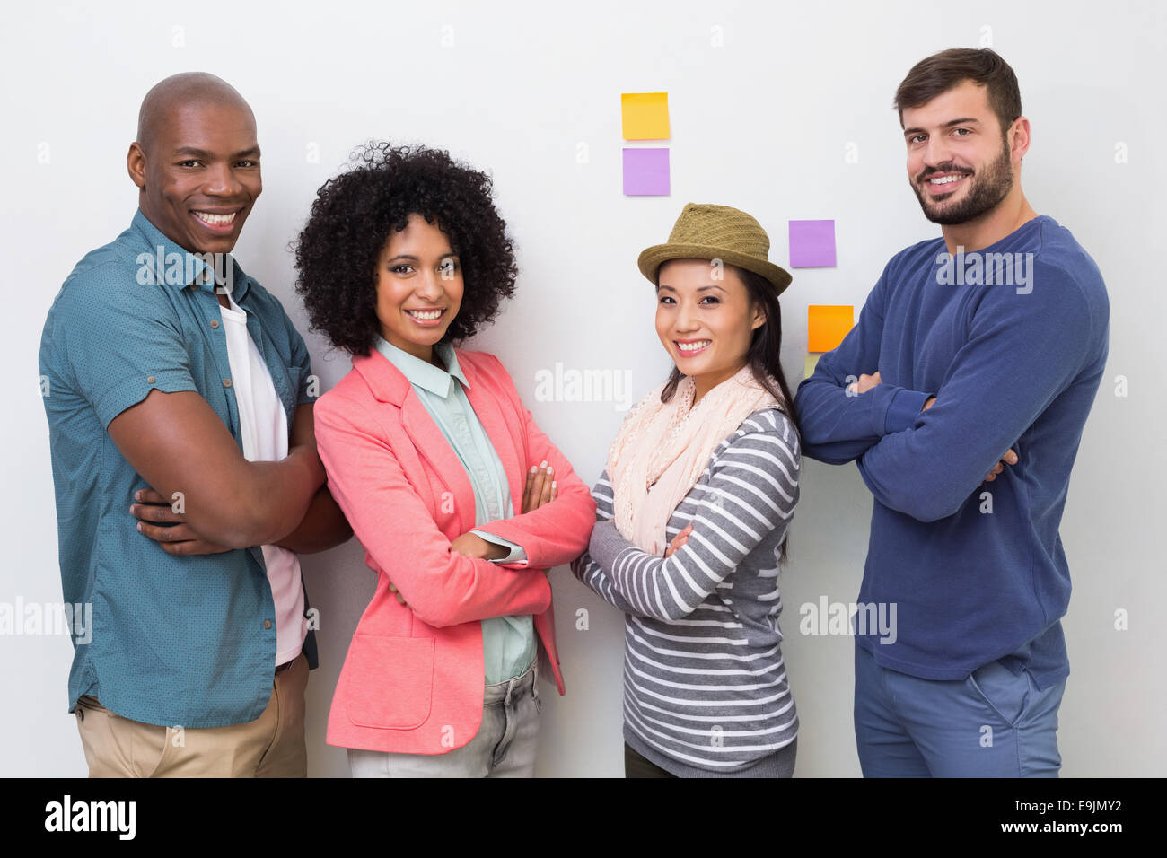 Creative business team with arms crossed in office Stock Photo - Alamy
