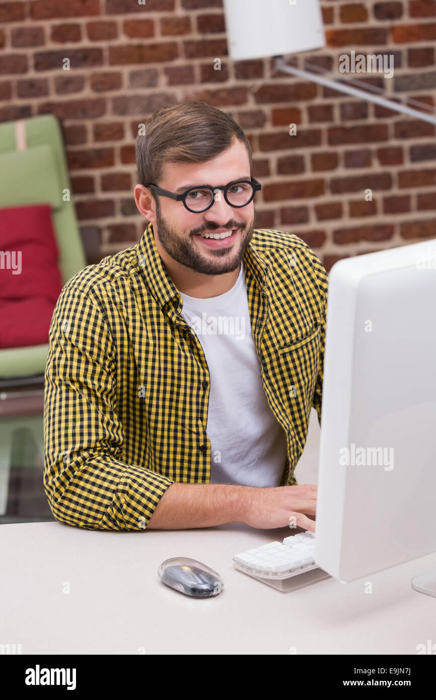 Smiling casual young man using computer Stock Photo - Alamy