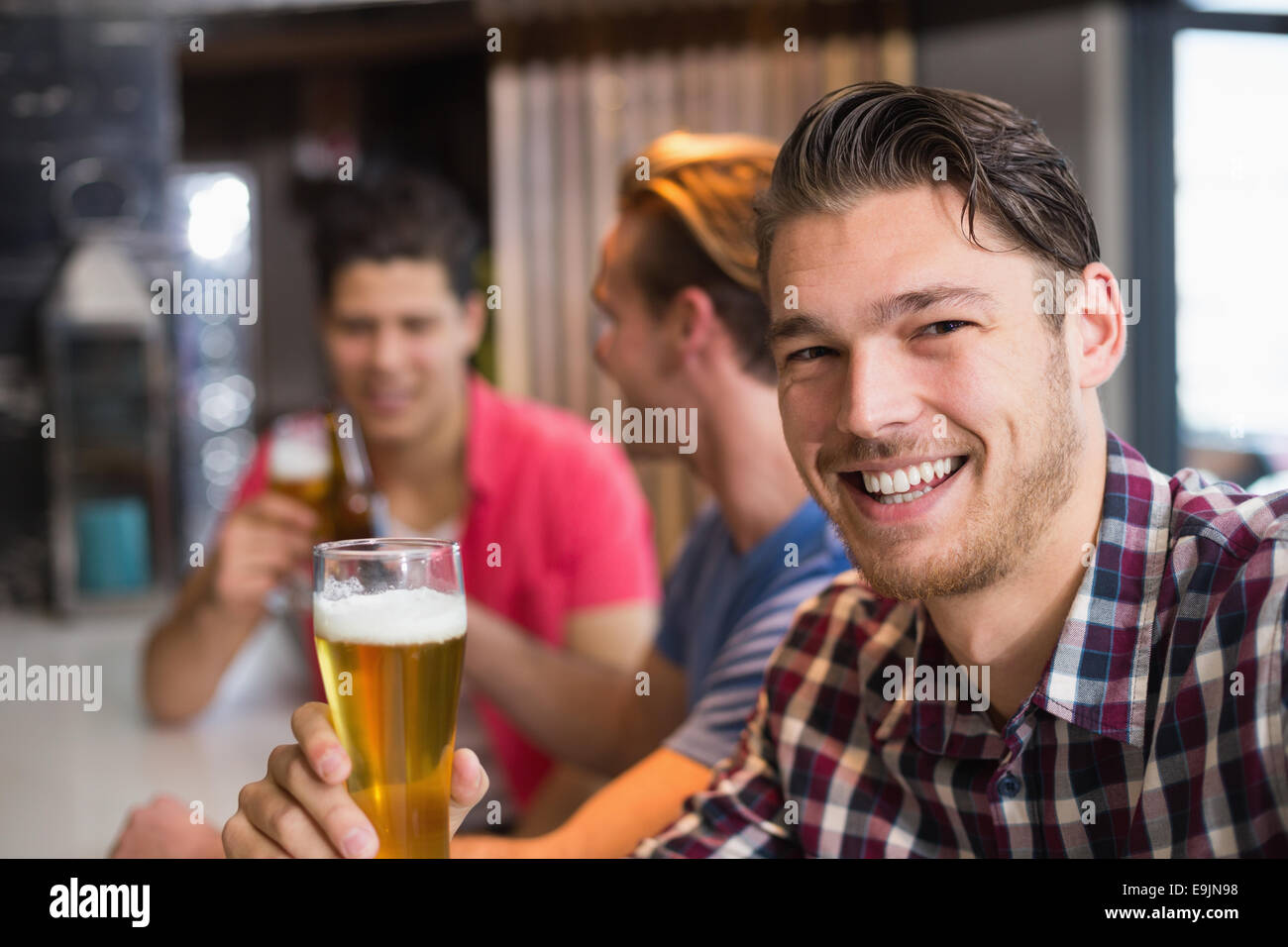 Young man holding pint of beer Stock Photo