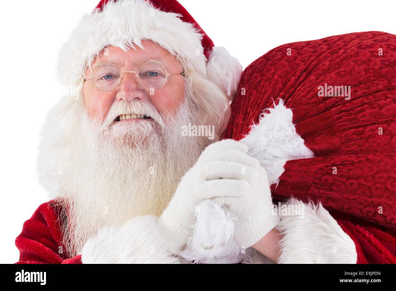 Santa carries his red bag and smiles Stock Photo