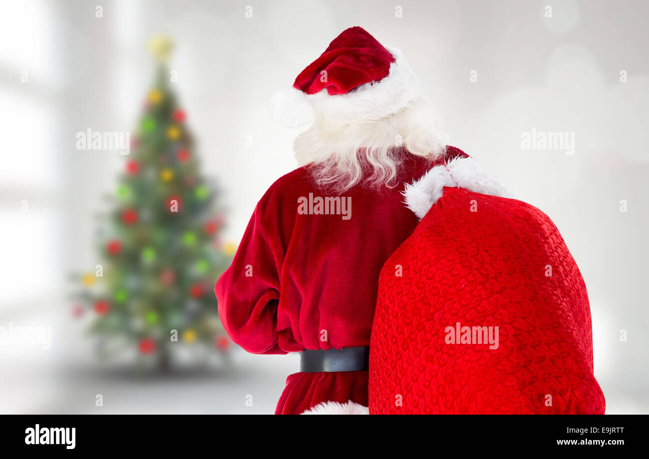 Composite image of santa claus carrying sack Stock Photo - Alamy