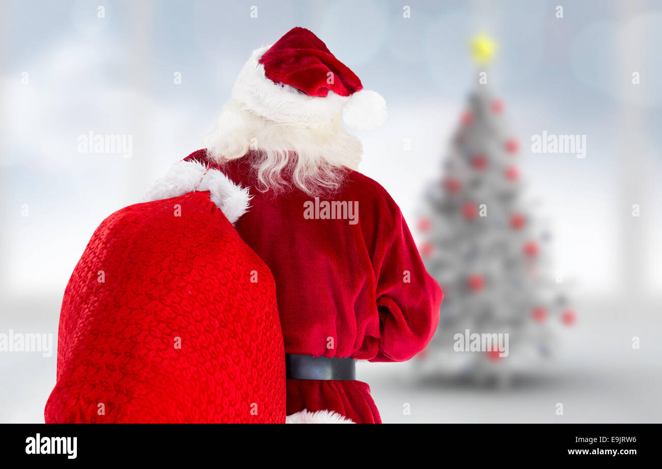 Composite image of santa claus carrying sack Stock Photo - Alamy