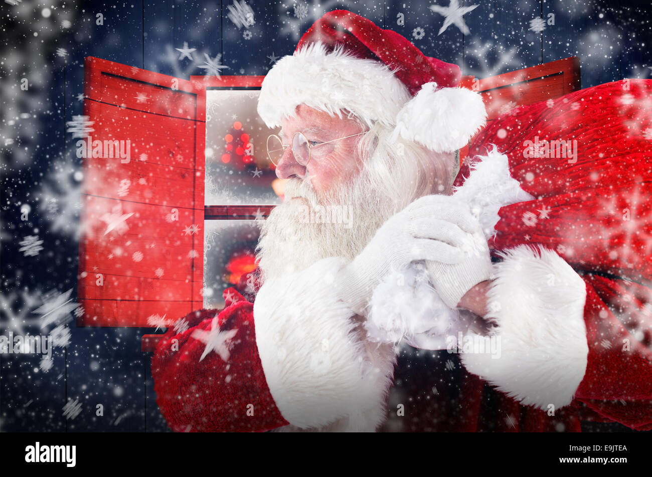 Composite image of santa claus carrying sack Stock Photo - Alamy