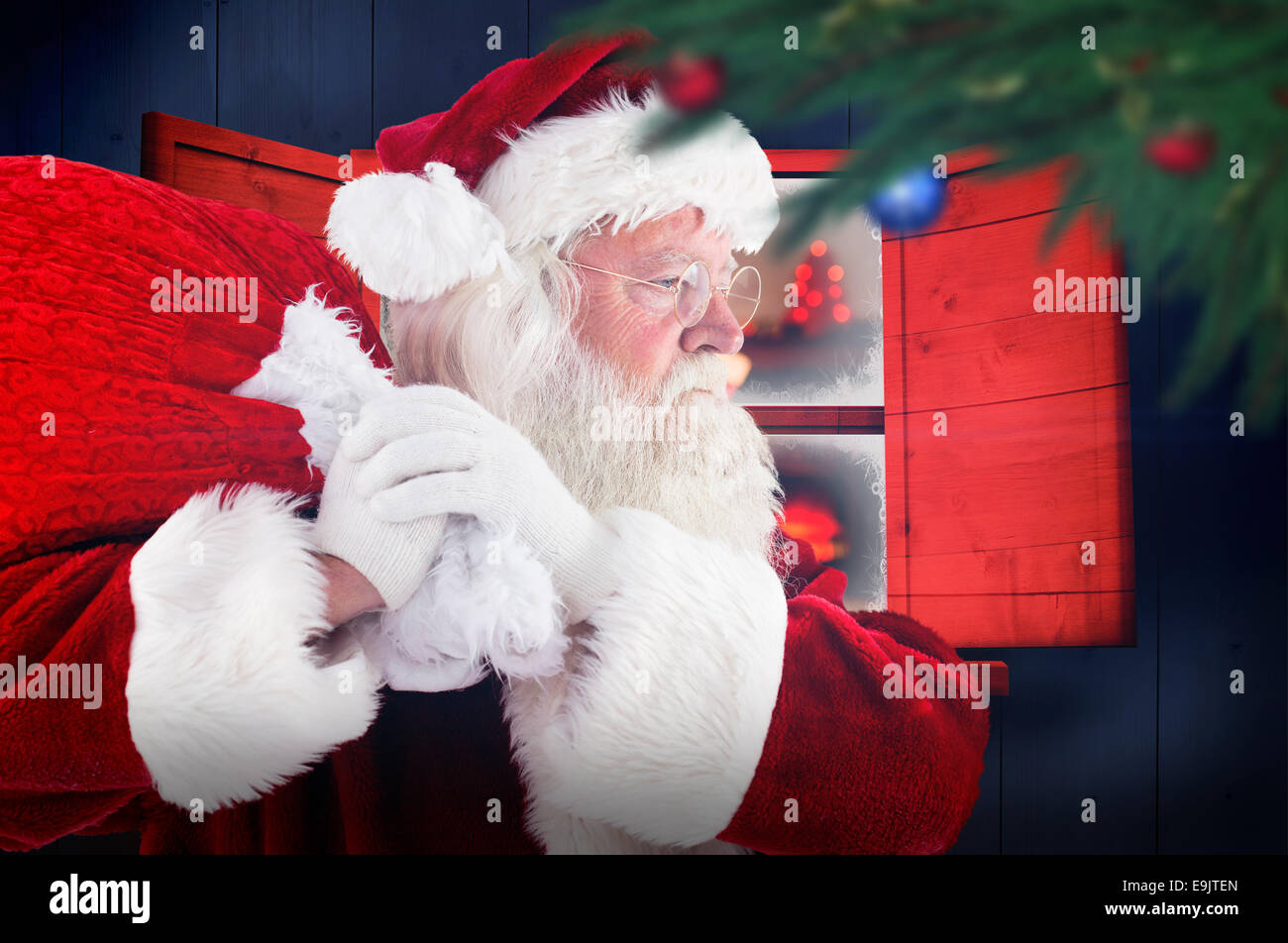 Composite image of santa claus carrying sack Stock Photo - Alamy