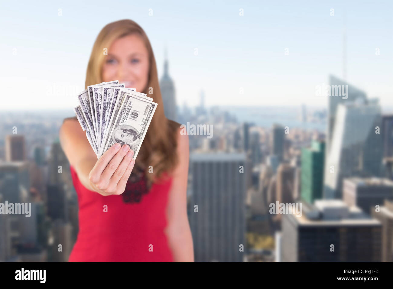 Composite image of pretty blonde showing wad of cash Stock Photo