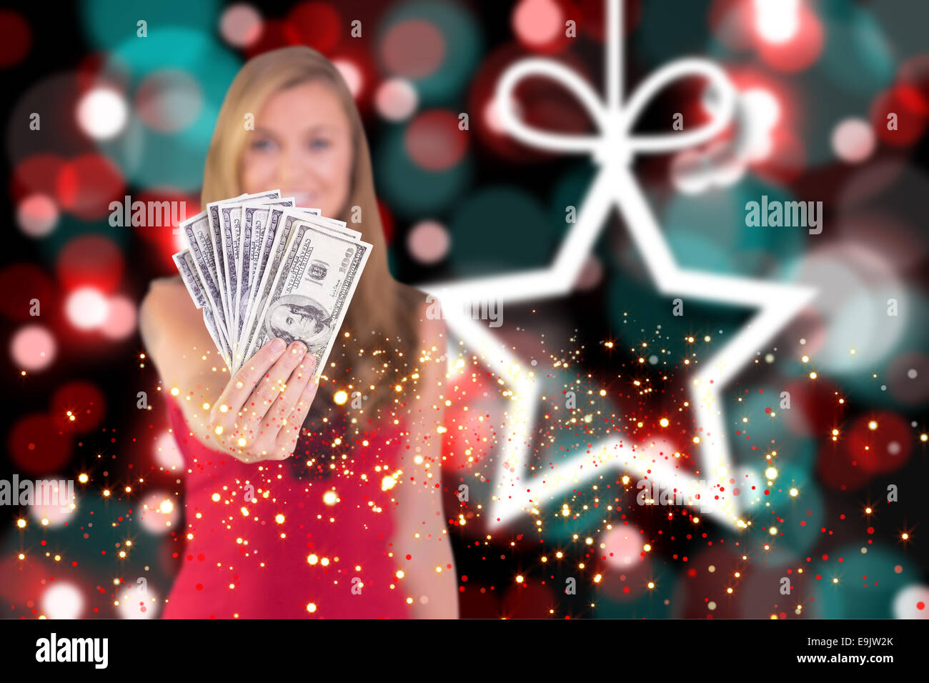 Composite image of pretty blonde showing wad of cash Stock Photo