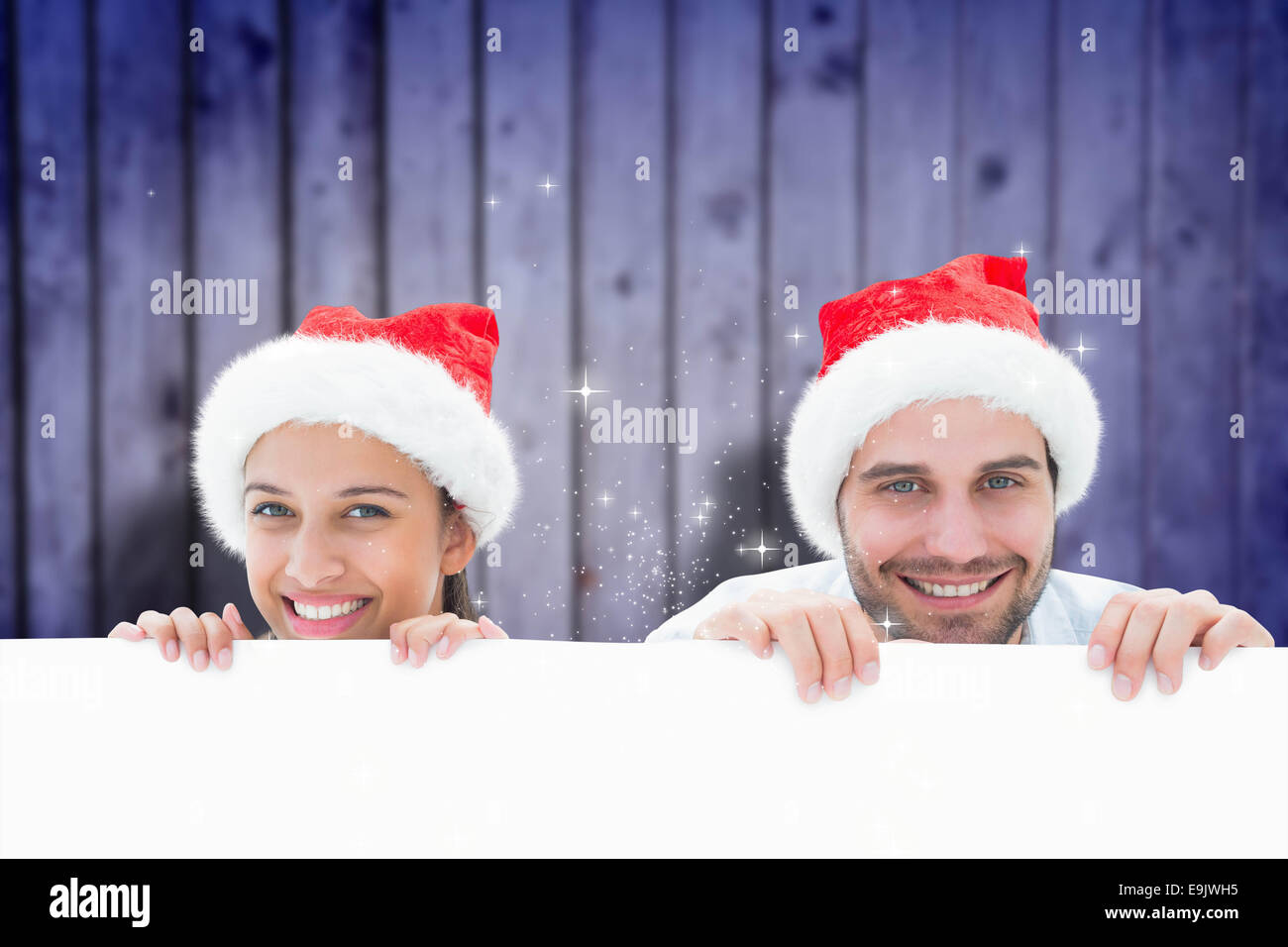 Composite image of festive young couple smiling at camera Stock Photo ...