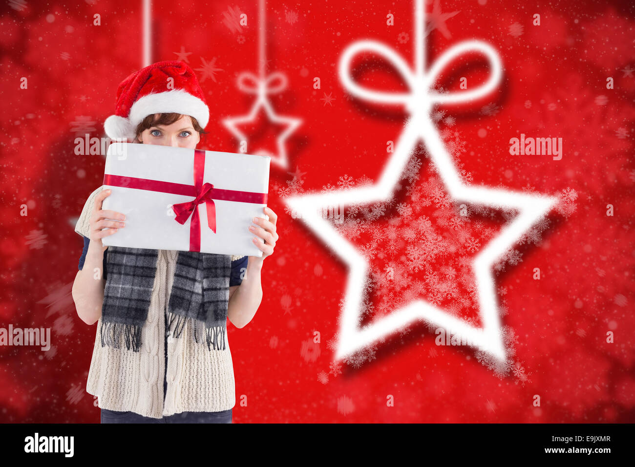 Composite image of woman holding a christmas present Stock Photo - Alamy