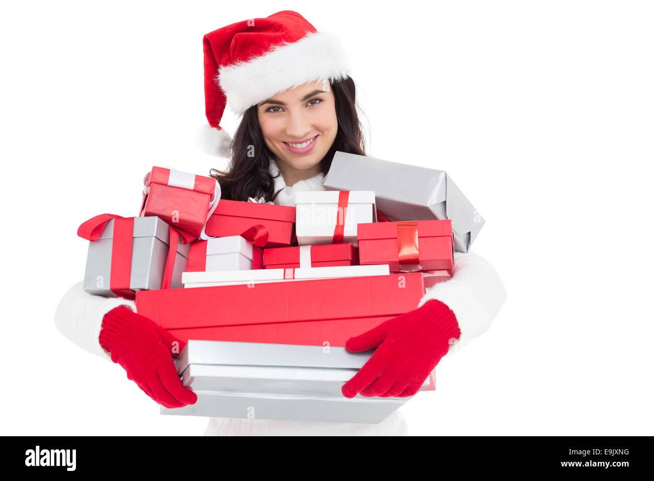 Smiling brunette in santa hat holding stack of presents Stock Photo - Alamy