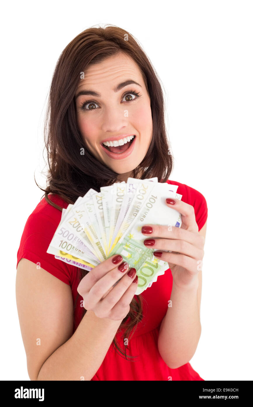 Excited brunette holding her cash Stock Photo - Alamy