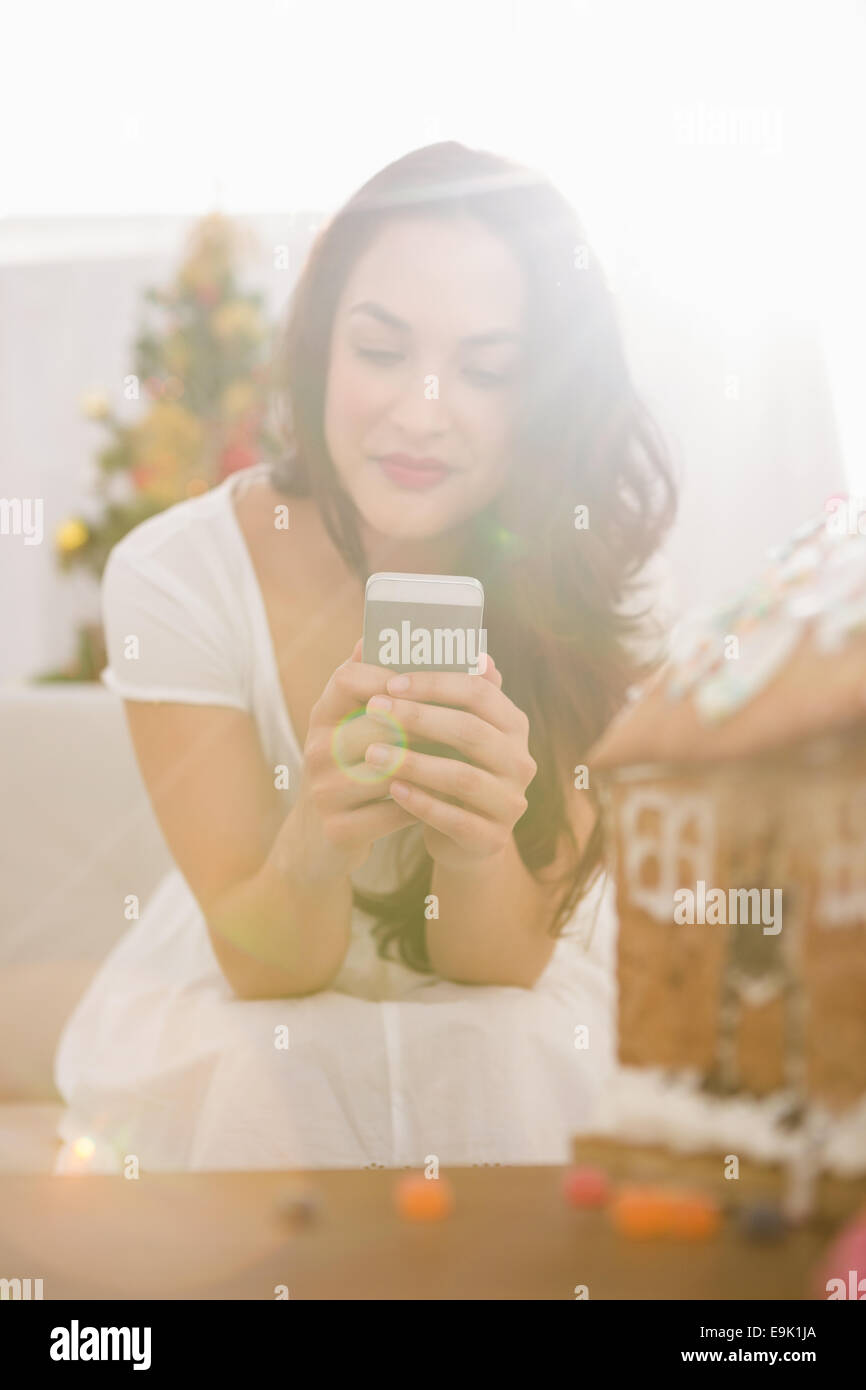 Beauty brunette using her smartphone on the sofa Stock Photo