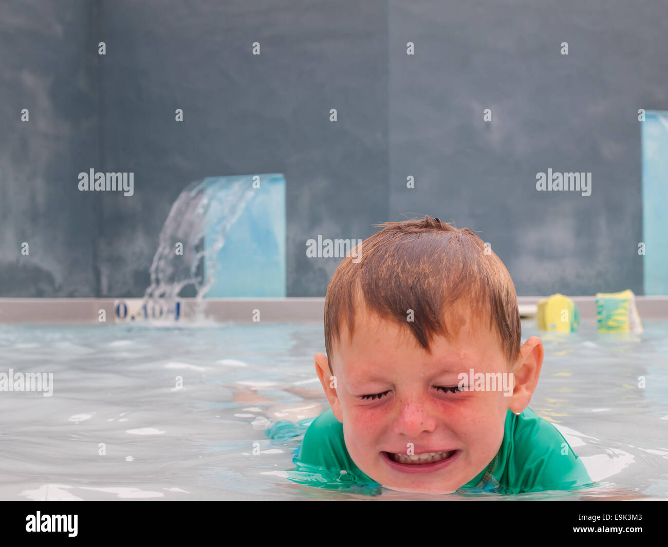 small boy playing in an outdoor swimming pool Stock Photo