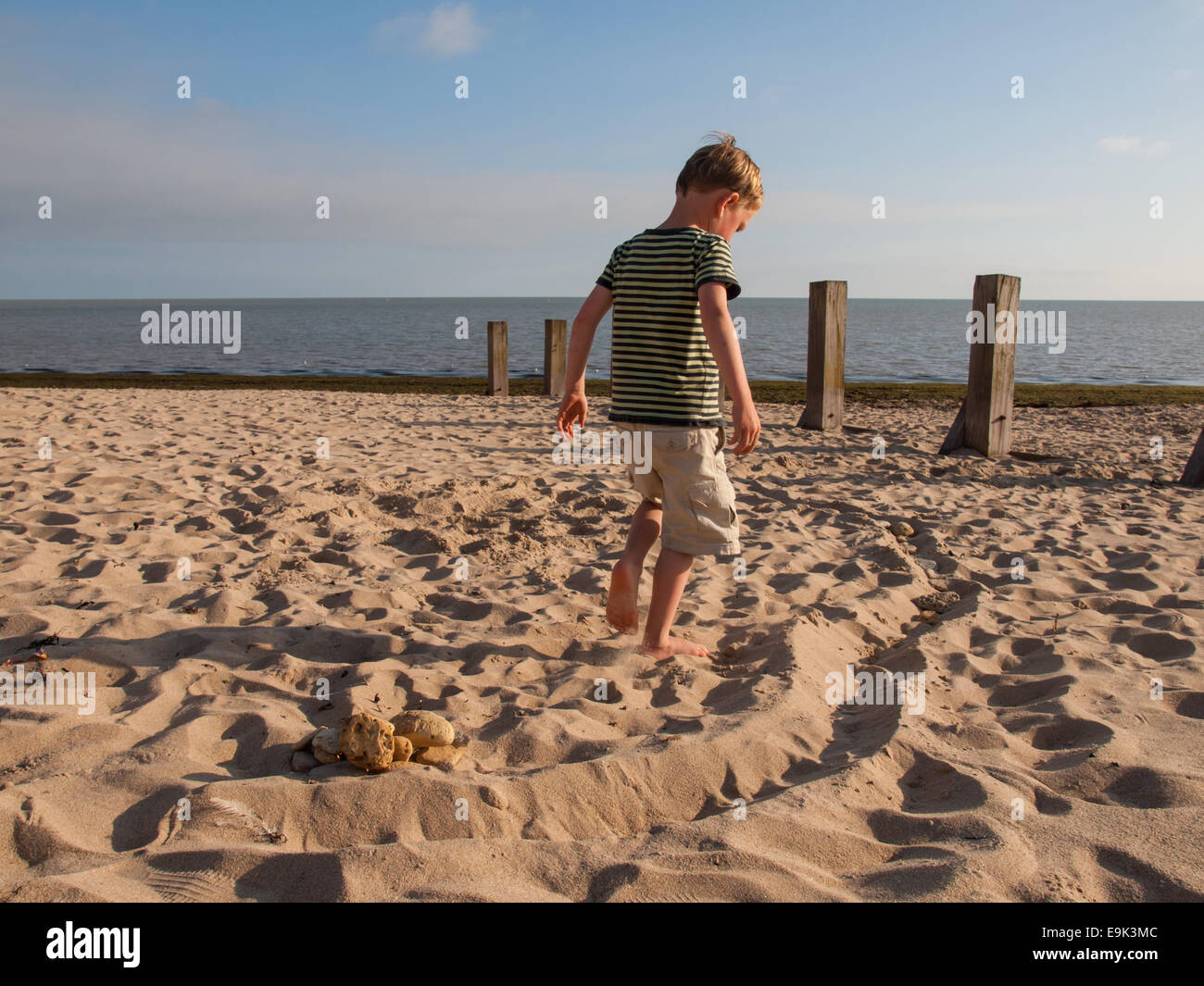 small boy playing on a sandy beach Stock Photo