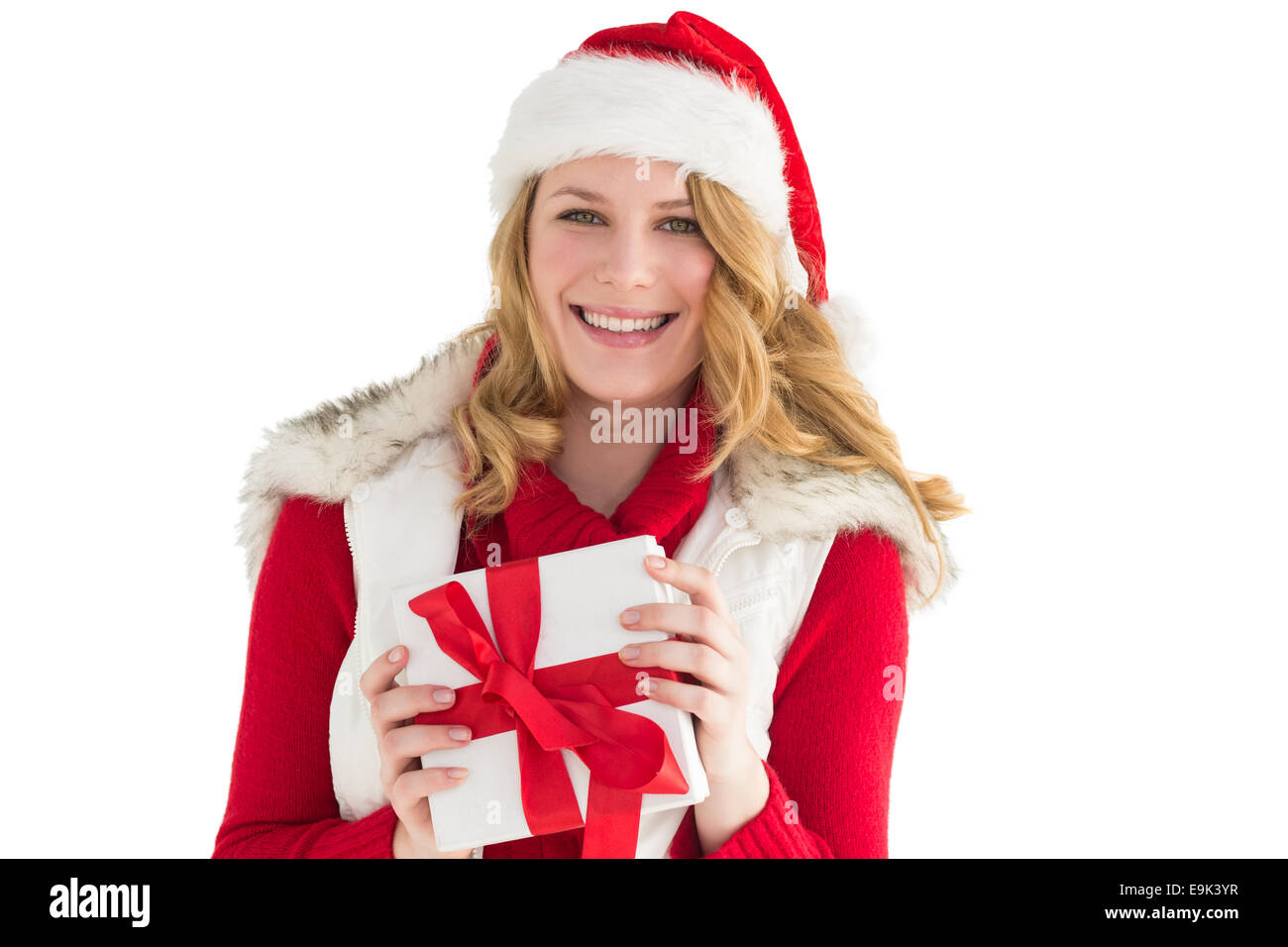 Smiling young woman in santa hat holding a gift Stock Photo - Alamy