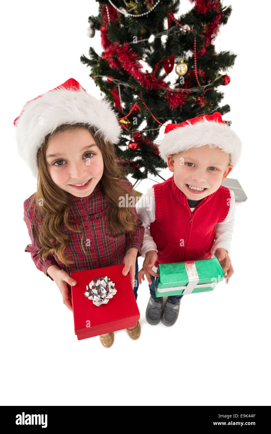 Festive little siblings smiling at camera holding gifts Stock Photo - Alamy