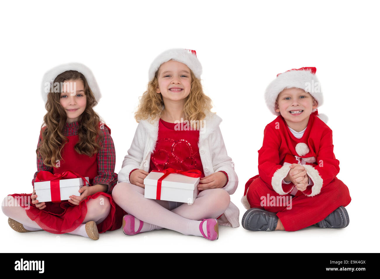 Festive little siblings smiling at camera holding gifts Stock Photo - Alamy