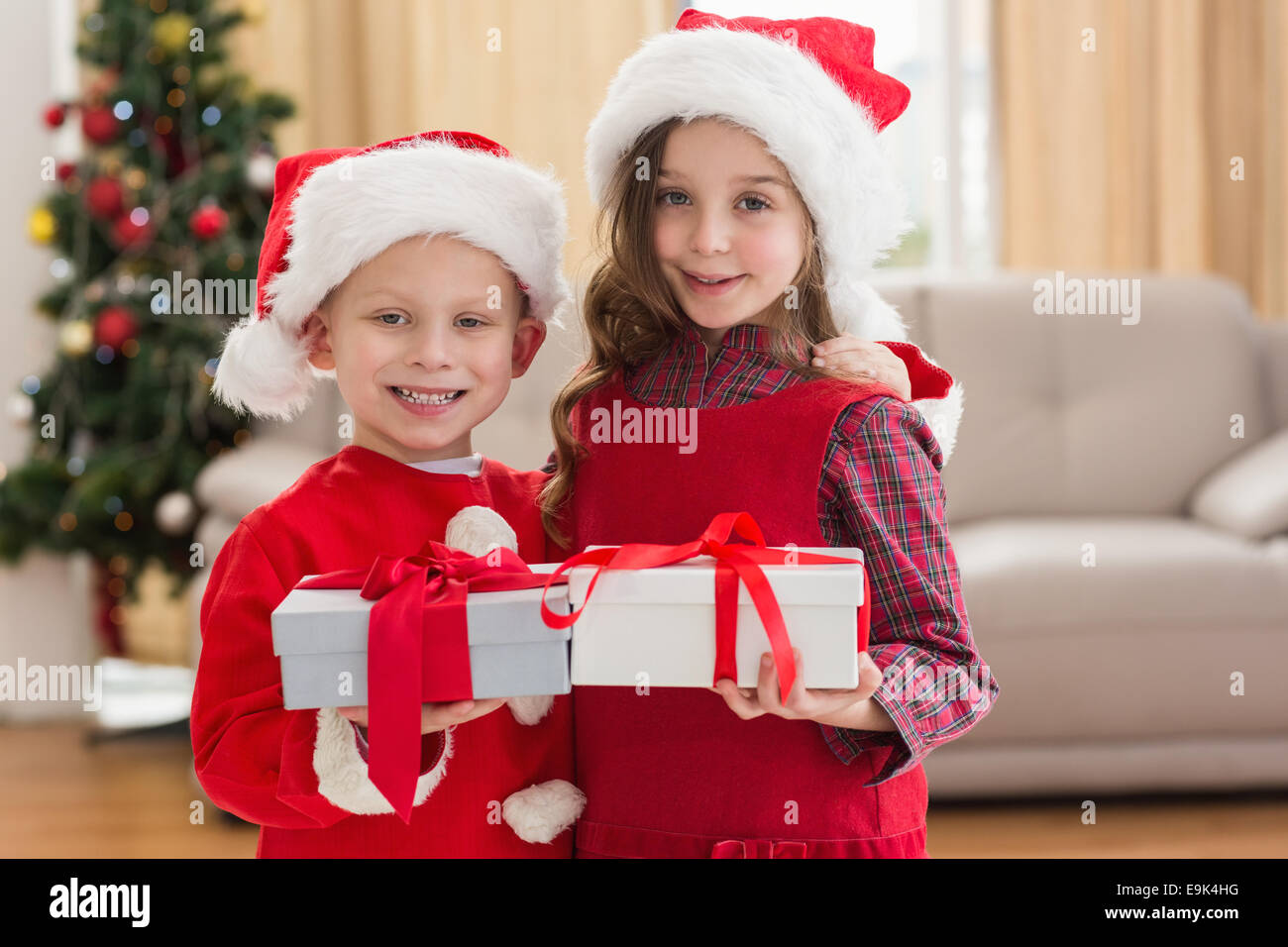 Festive little siblings holding gifts Stock Photo