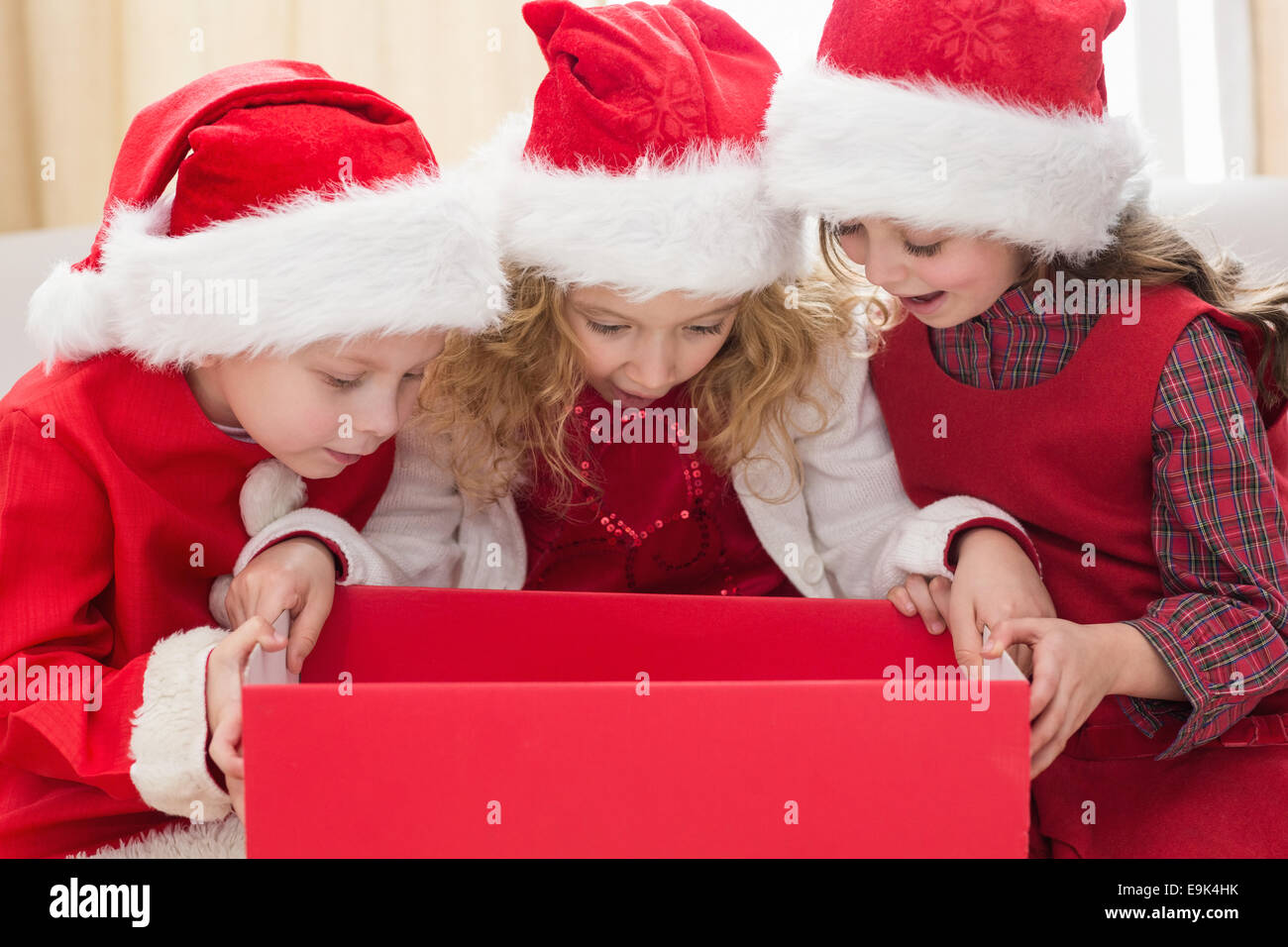 Festive little siblings looking at gift Stock Photo - Alamy
