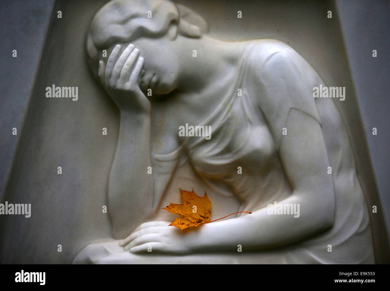 Cologne, Germany. 29th Oct, 2014. An autumn leaf on a headstone in the Melaten cemetery in Cologne, Germany, 29 October 2014. 1 November 2014 is All Saints' Day. Credit:  dpa picture alliance/Alamy Live News Stock Photo