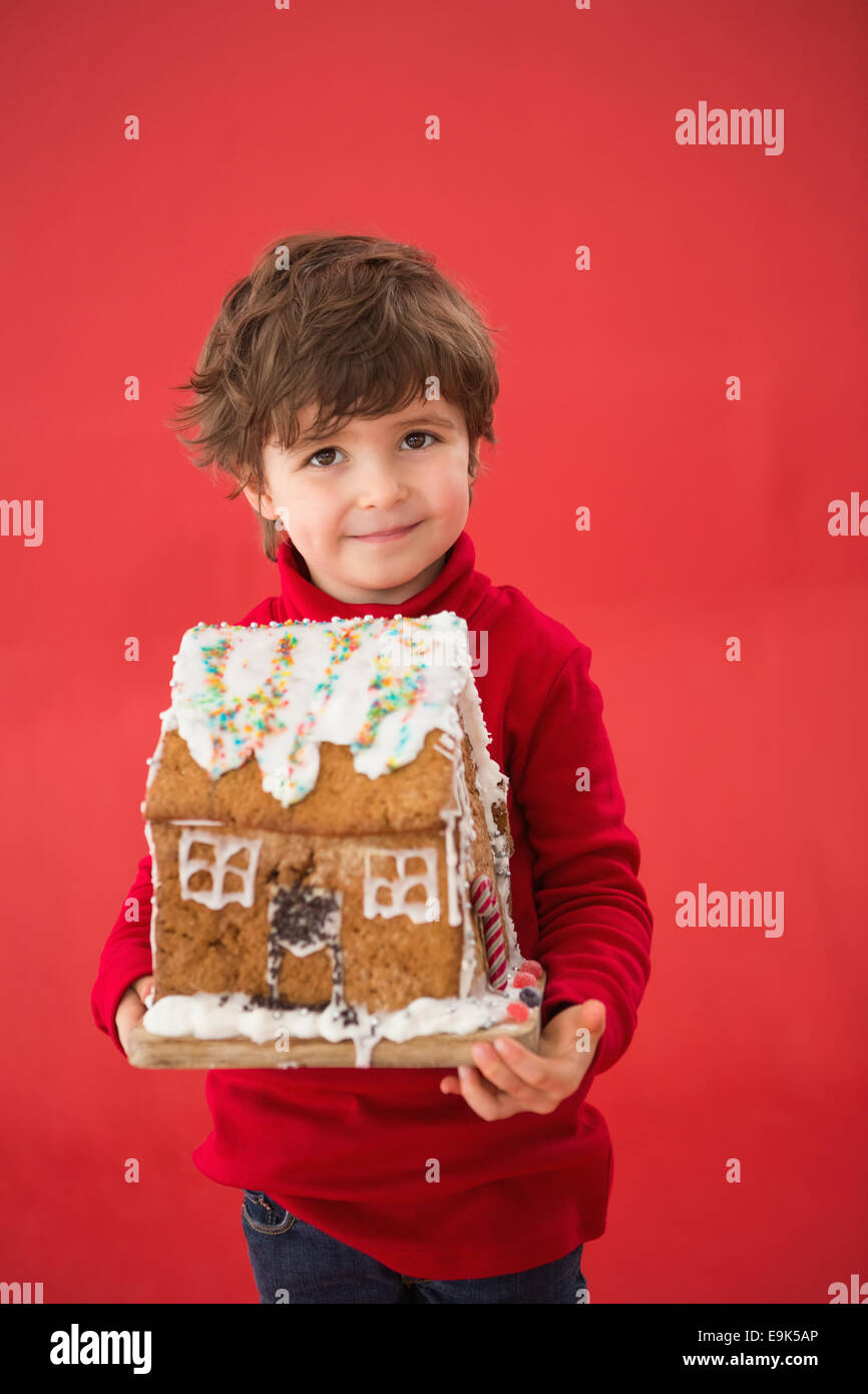 Festive little boy holding gingerbread house Stock Photo Alamy