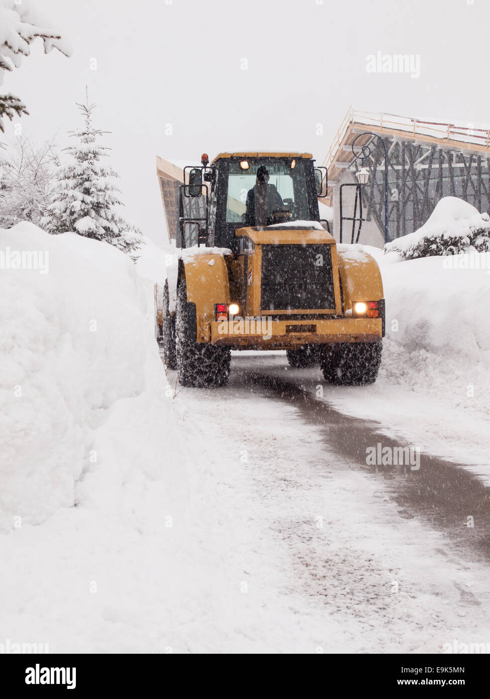 heavy snow plow clearing road with falling snow in a french ski resort