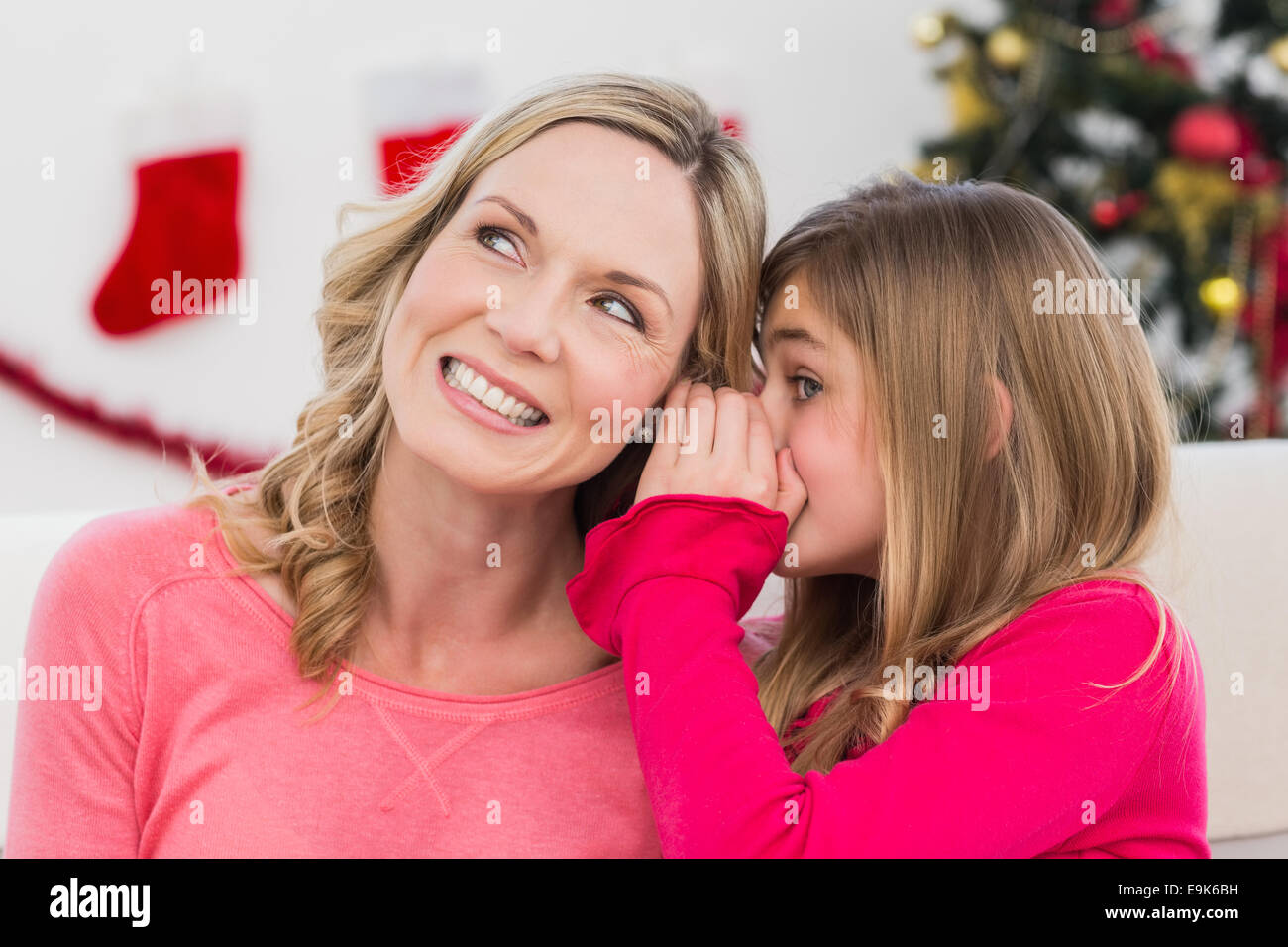 Daughter telling her mother a christmas secret Stock Photo