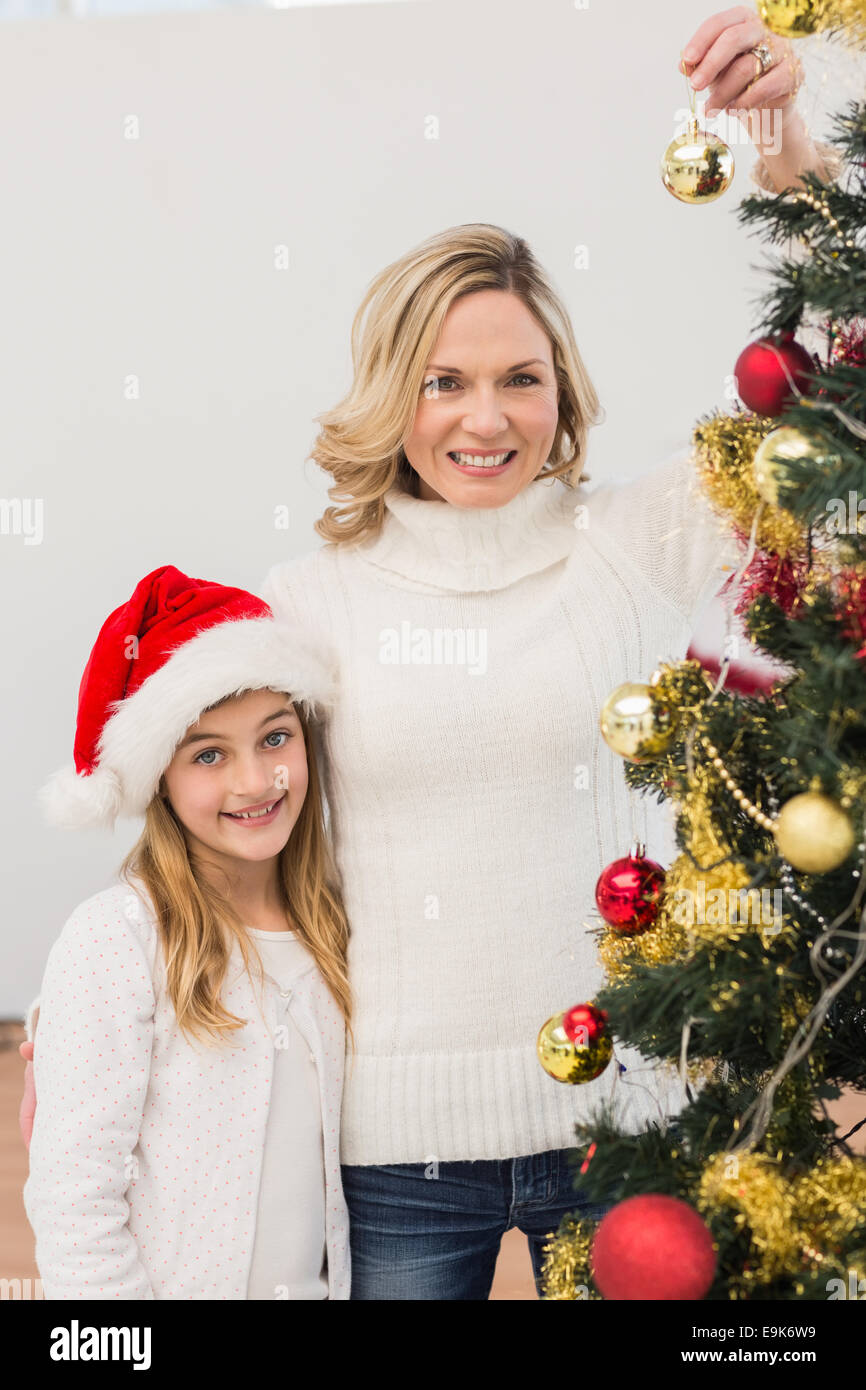 Festive mother and daughter decorating christmas tree Stock Photo