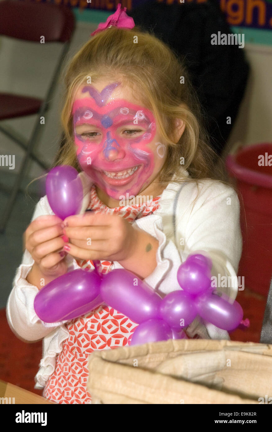 Young girl playing with balloon for Liphook Carnival, 25 October 2014, Liphook, Hampshire, UK. Stock Photo