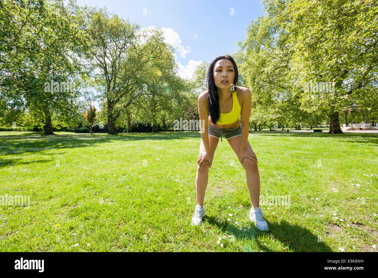 Full length of tired fit woman taking a break while exercising in park Stock Photo