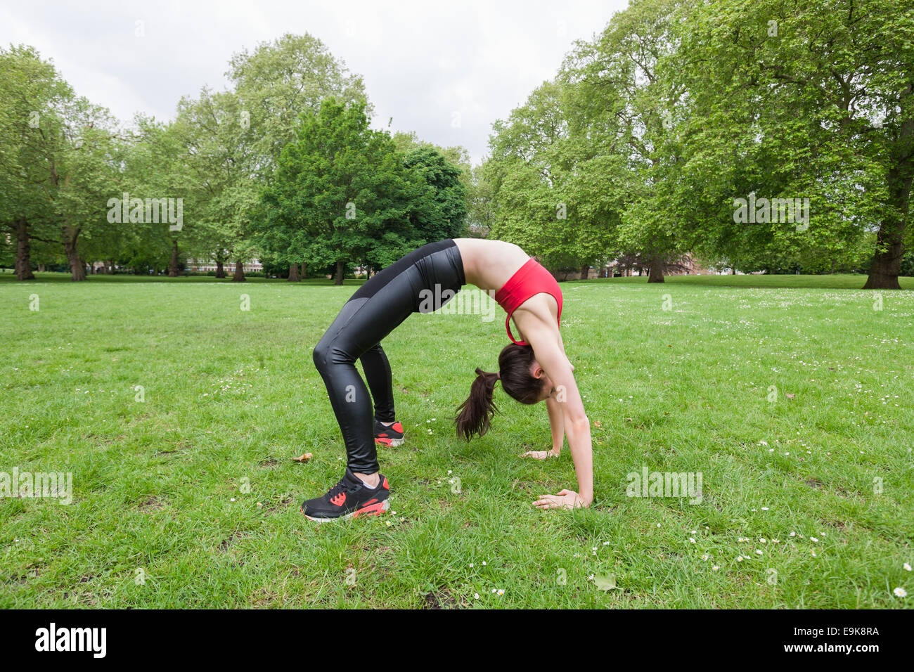 Full length side view of fit woman exercising in park Stock Photo