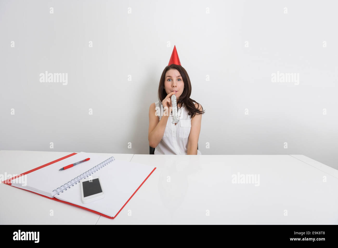 Young woman blowing party horn hi-res stock photography and images - Alamy