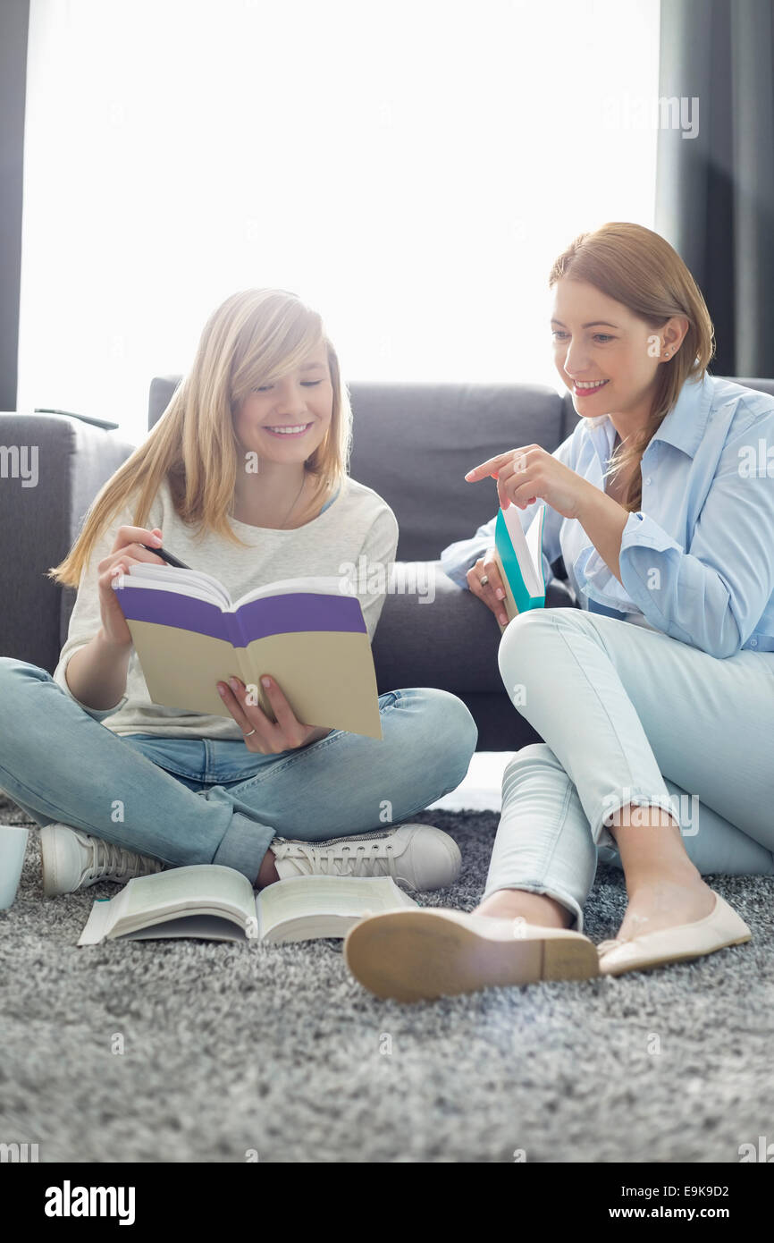 Mother assisting daughter in homework at home Stock Photo
