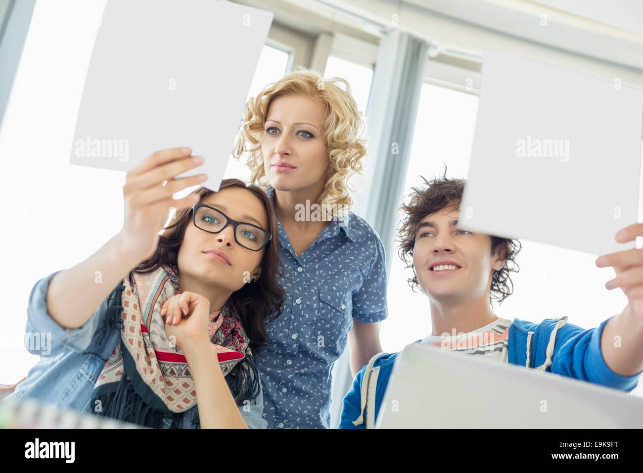 Creative businesspeople analyzing photographs in office Stock Photo