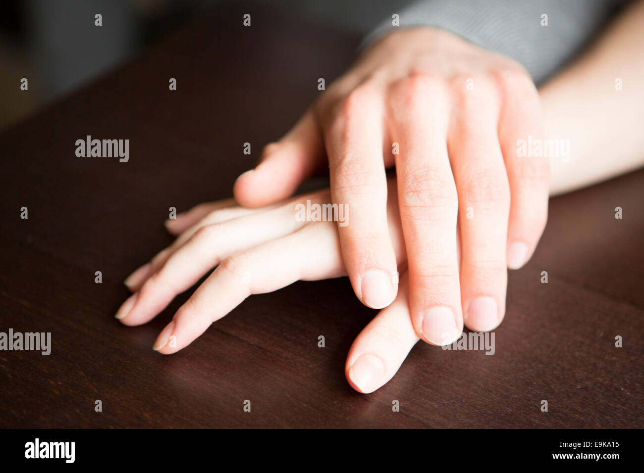 Loving couple's hands on table Stock Photo