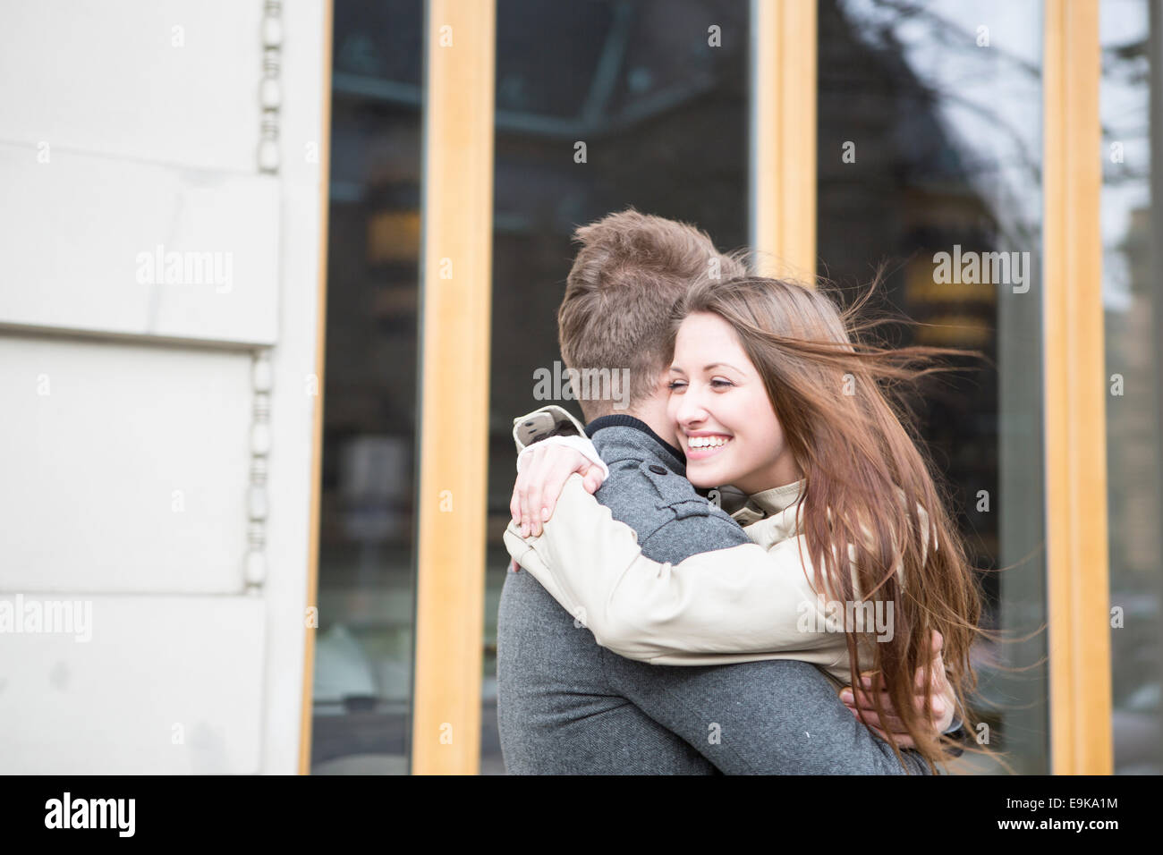 Side view of romantic couple hugging outside cafe Stock Photo