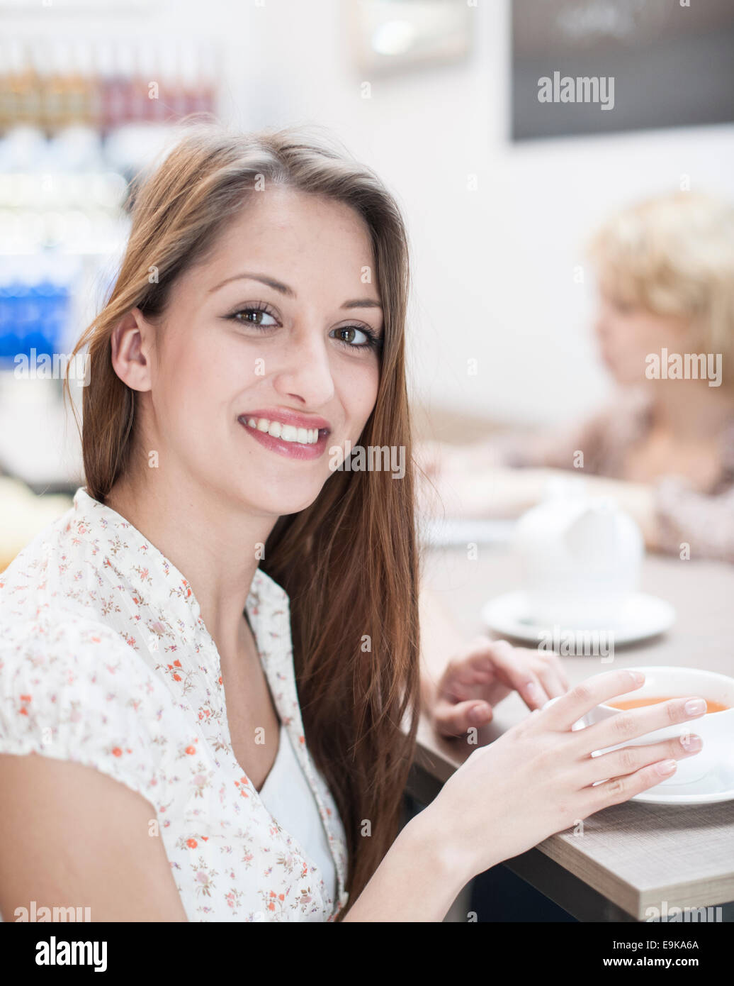Portrait of beautiful young woman having coffee at table in cafe Stock Photo