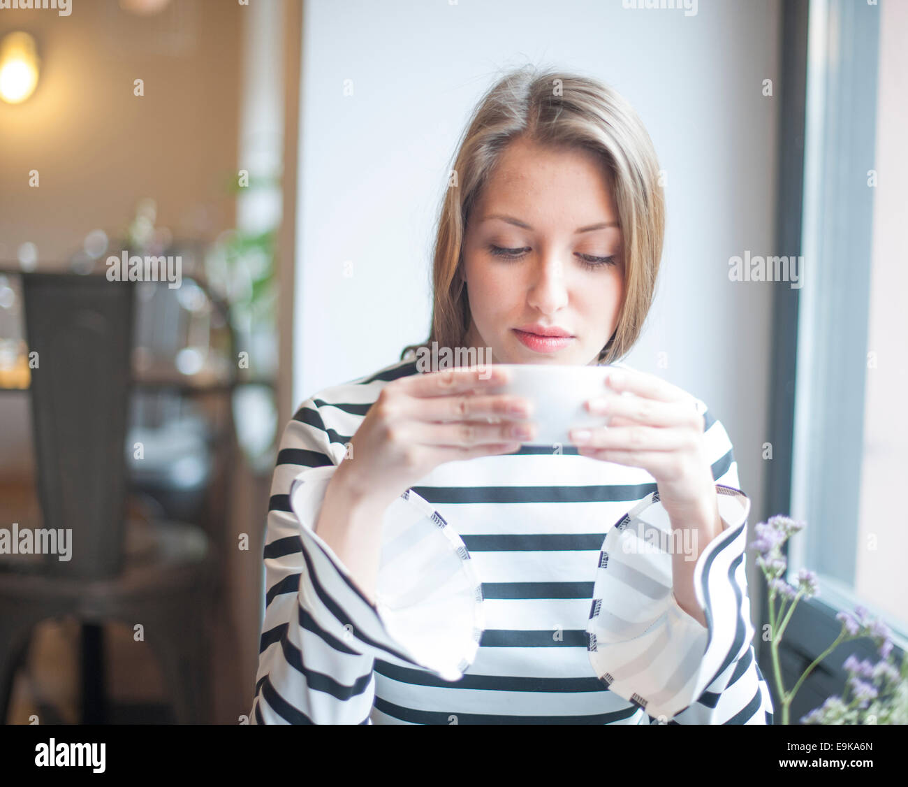 Beautiful young woman drinking coffee in cafe Stock Photo Alamy
