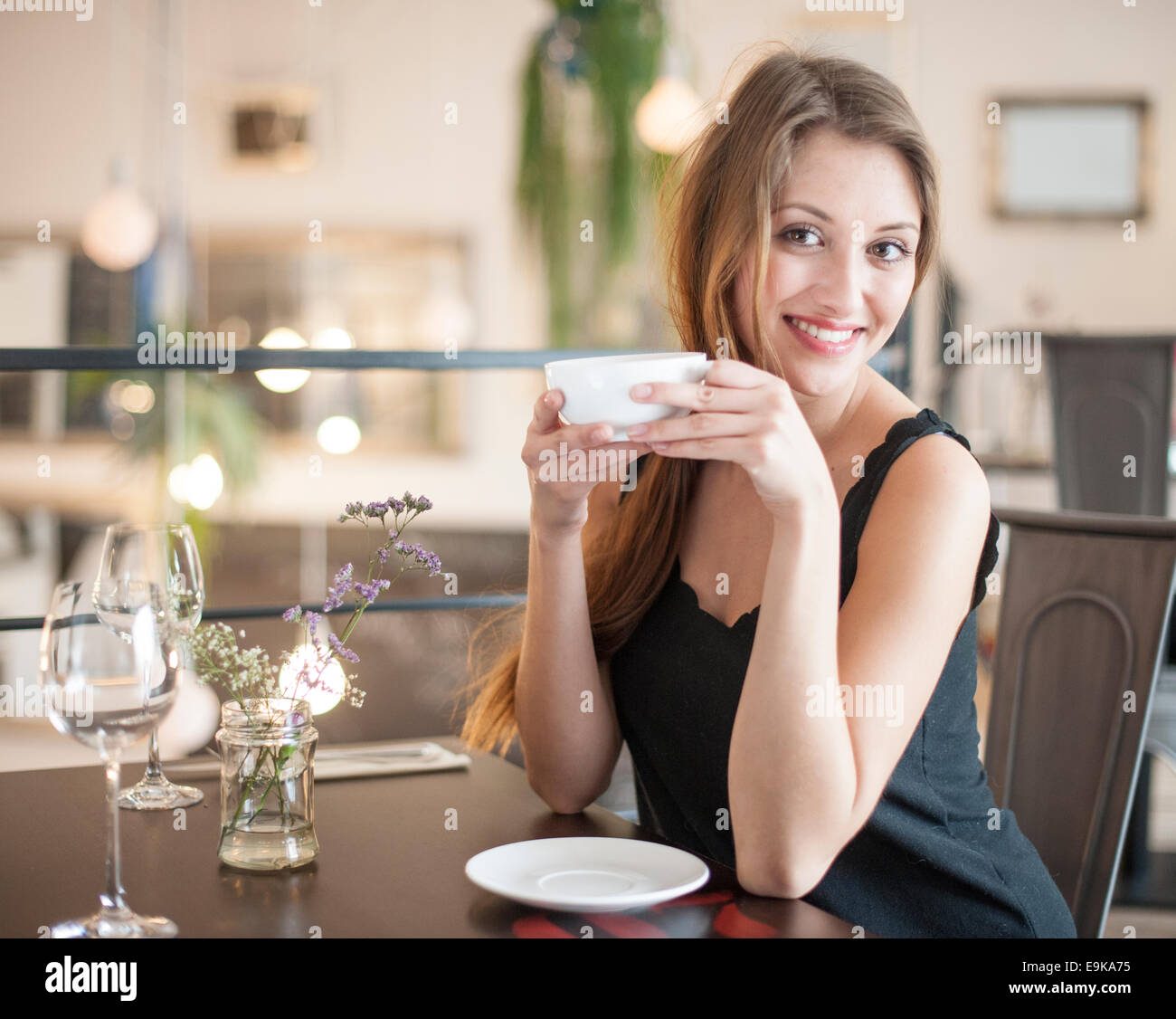 Portrait of happy young woman having coffee at restaurant Stock Photo