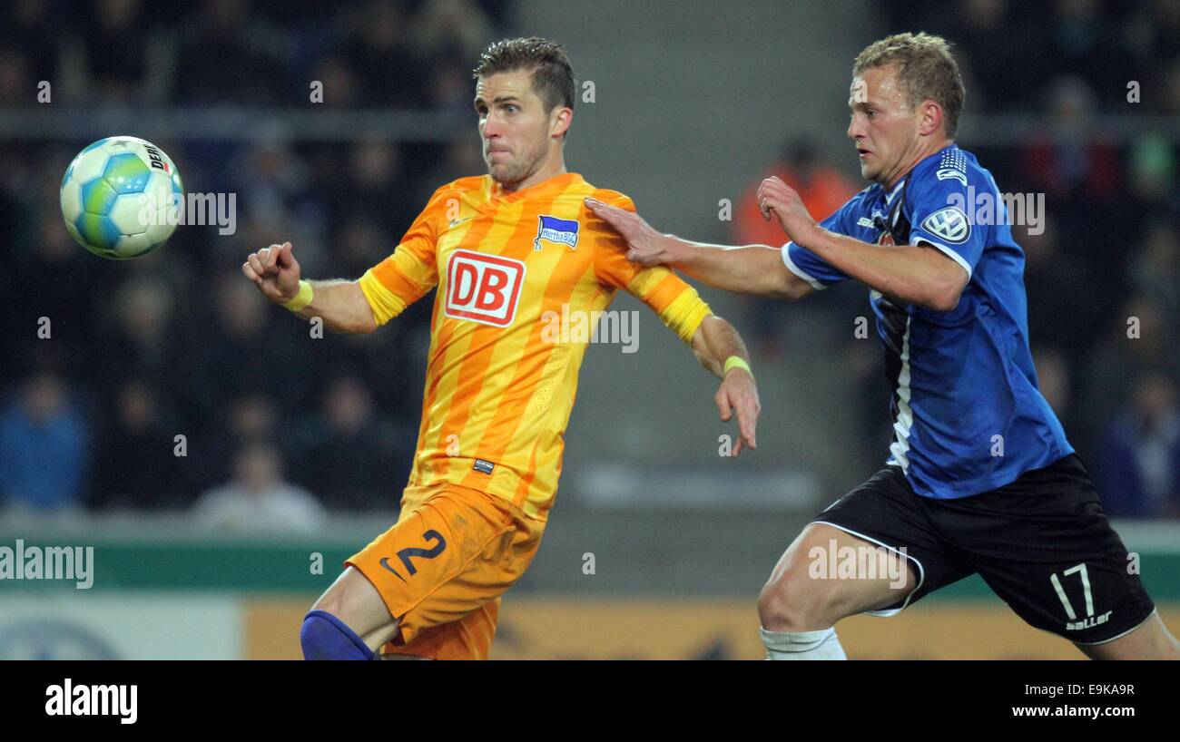 Bielefeld, Germany. 28th Oct, 2014. Berlin's Peter Pekarik and Bielefeld's Christoph Hemlein during the German DFB-Cup match between Arminia Bielefeld and Hertha BSC at the Schueco Arena in Bielefeld, Germany, 28 October 2014. Credit:  dpa picture alliance/Alamy Live News Stock Photo