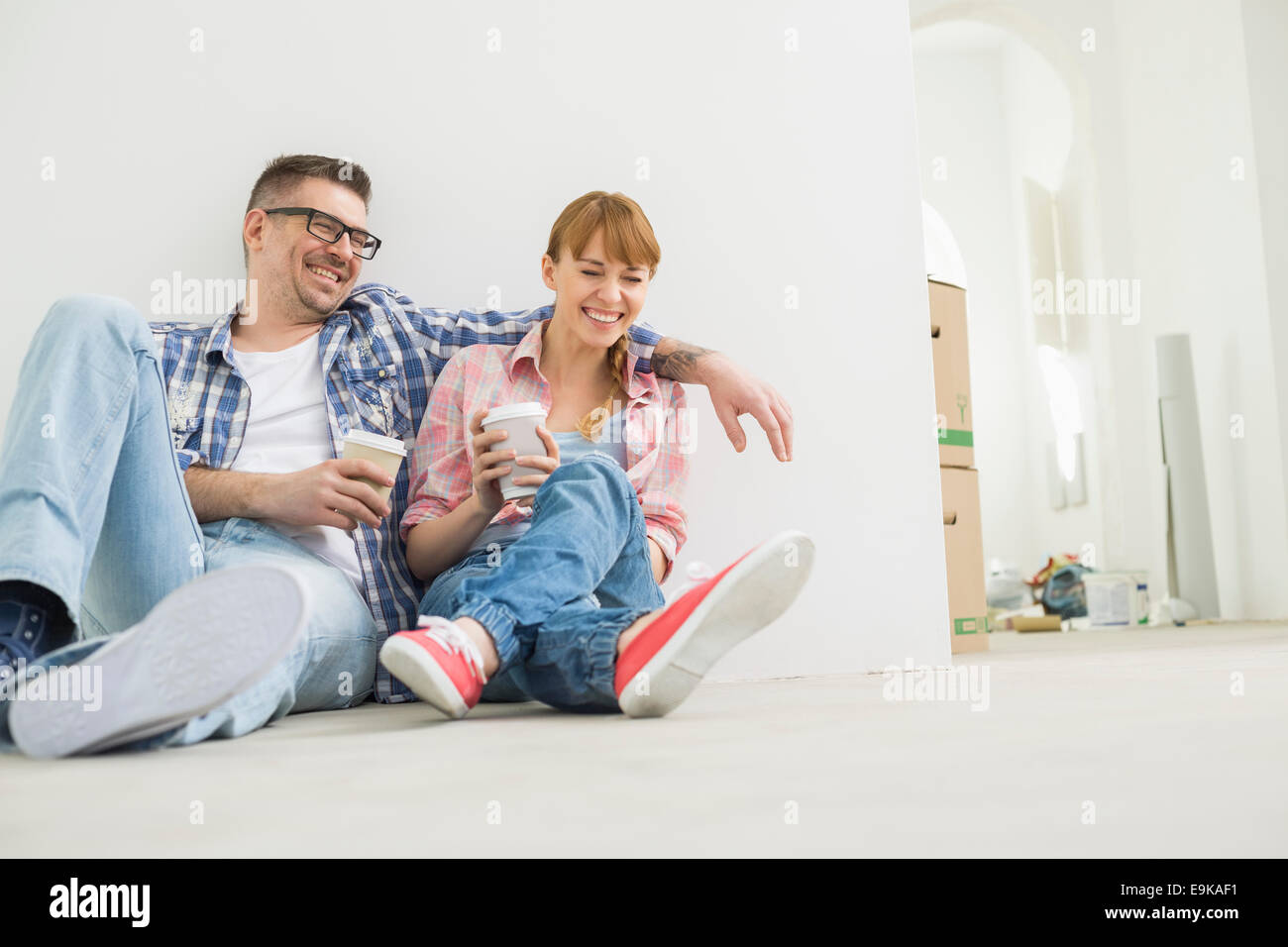 Full-length of cheerful couple with coffee cups in new house Stock Photo