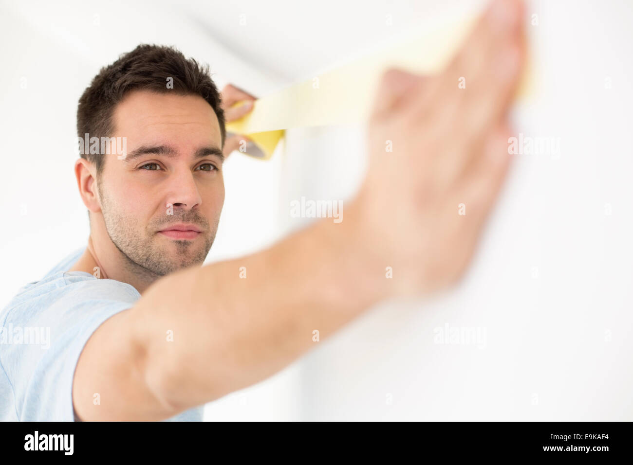 Man applying duct tape on wall Stock Photo Alamy