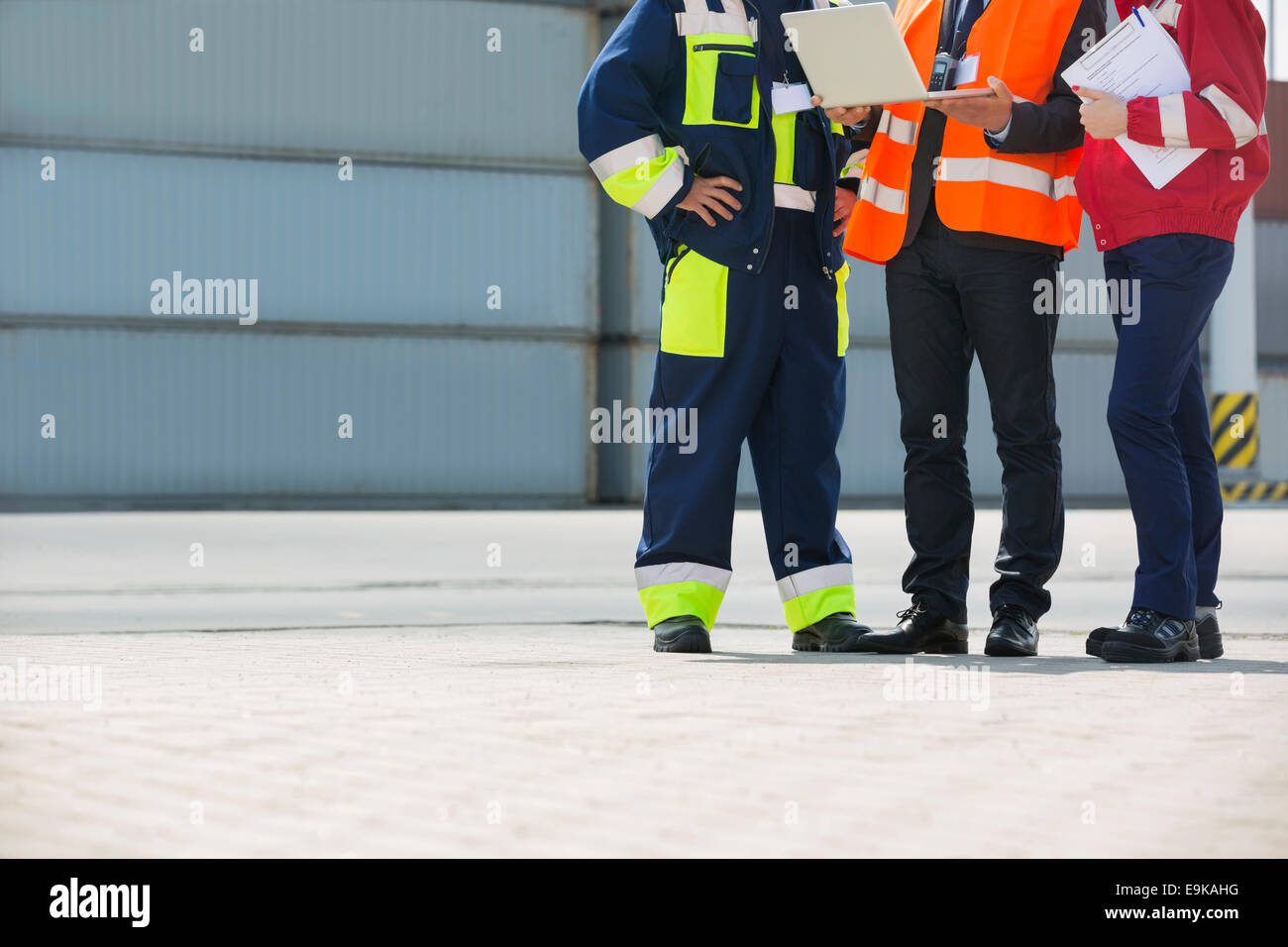 Low section of workers discussing in shipping yard Stock Photo