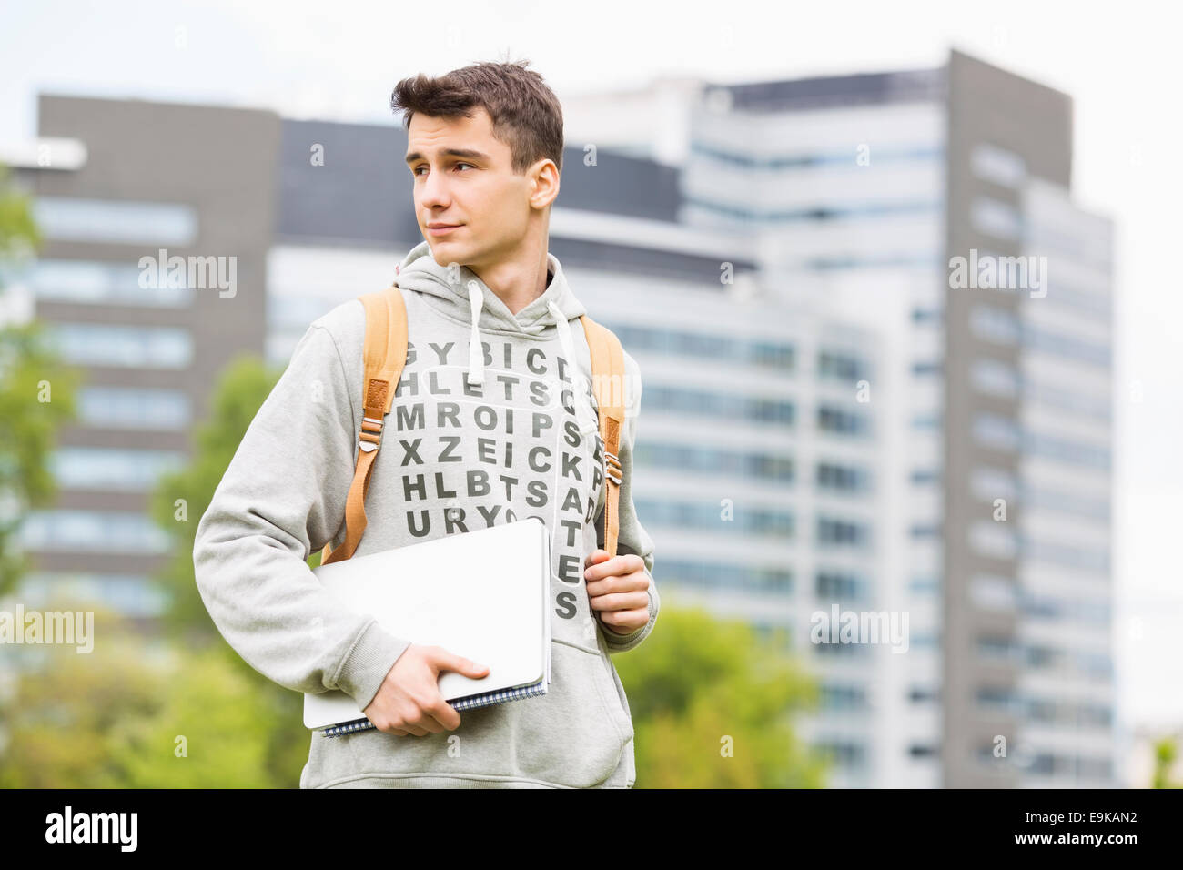 Young male university student holding books at campus Stock Photo
