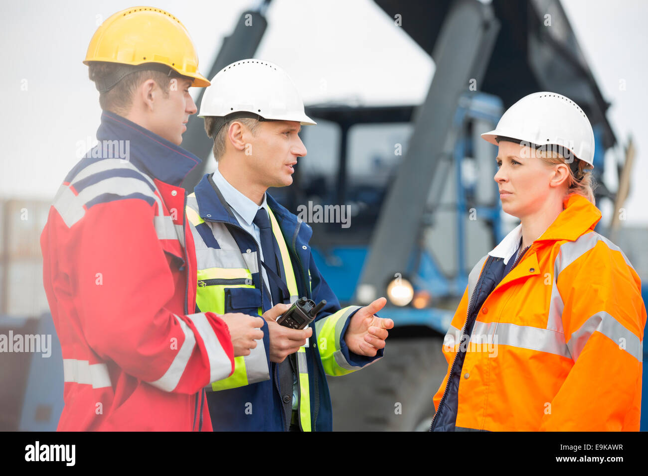 Workers discussing in shipping yard Stock Photo