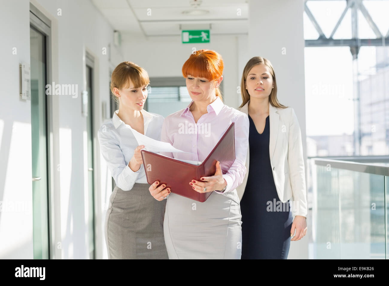 Businesswomen discussing over documents at office hallway Stock Photo