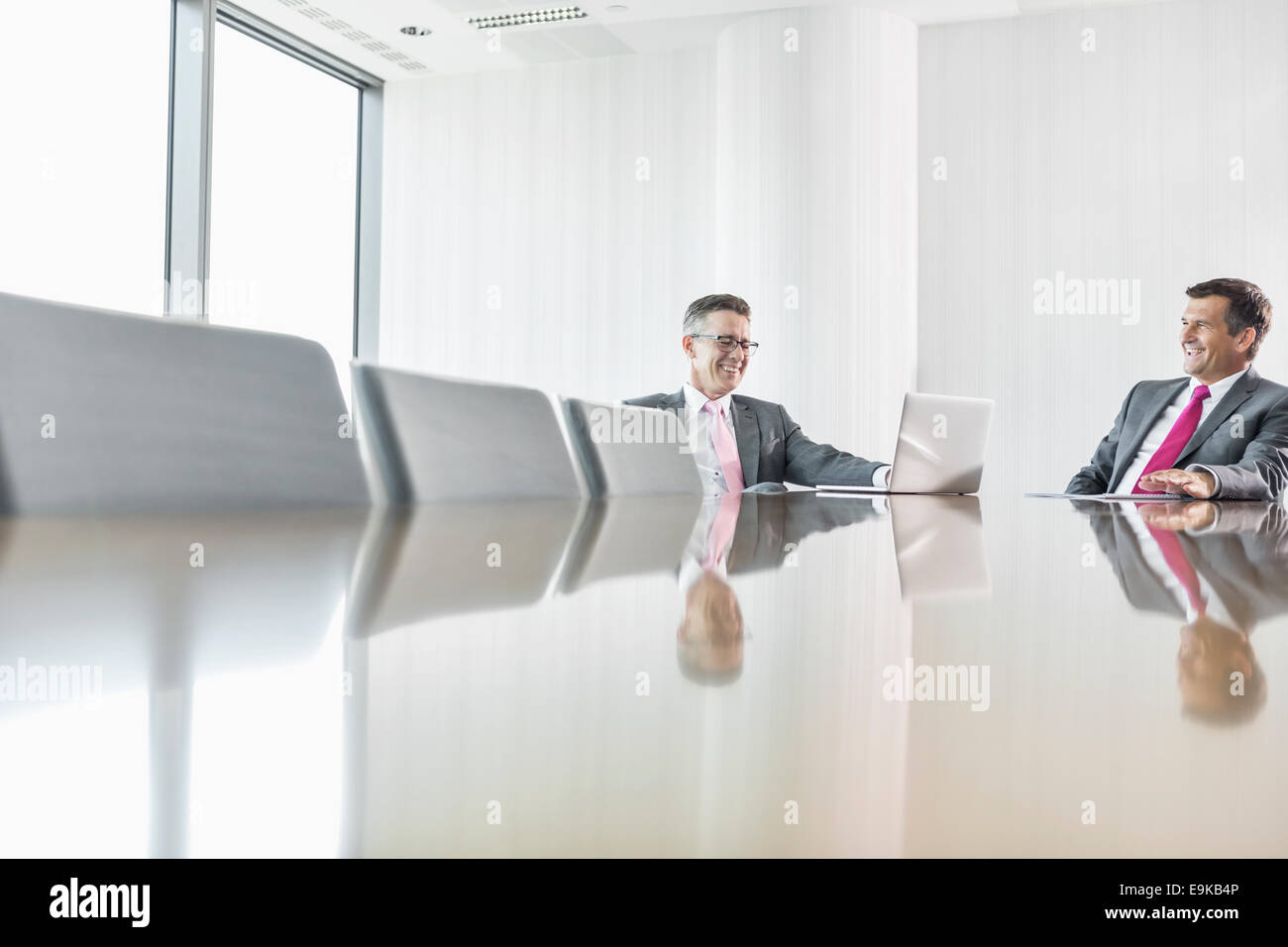 Smiling businessmen talking in conference room Stock Photo