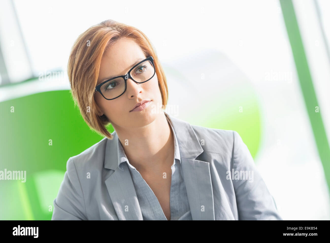 Young businesswoman looking away in office Stock Photo