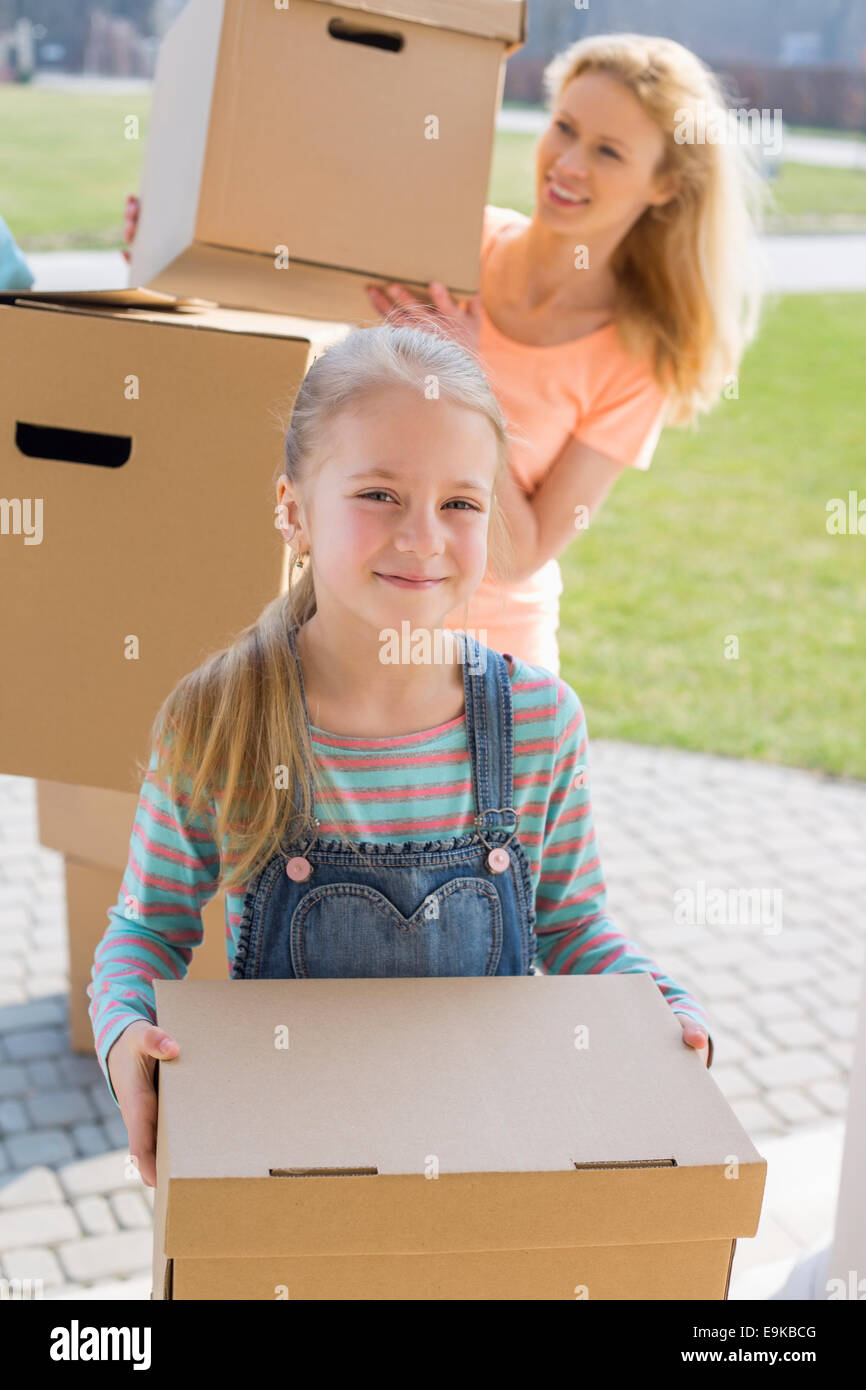 Mother and daughter with cardboard boxes moving into new house Stock Photo