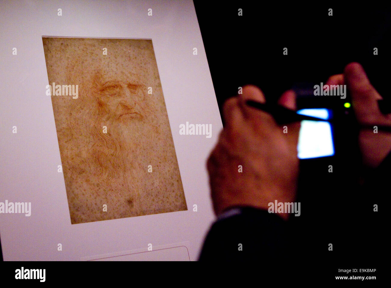 Torino, Italy. 28th October 2014. Torino, Italy. 28th October 2014. A visitor takes a picure of Leonardo da Vinci self portrait (portrait of a man in red chalk).  An exhibition of Leonardo and other artist drawings opens in the vaults of the Royal Library of Torino, Italy. Stock Photo